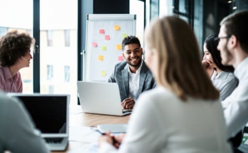 A typical stock photo showing people at work, smiling while looking at their laptops.